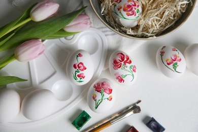 Photo of Painting Easter eggs on white table, flat lay