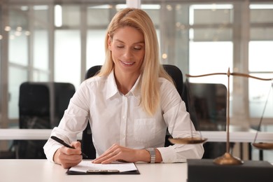 Photo of Portrait of smiling lawyer working at table in office