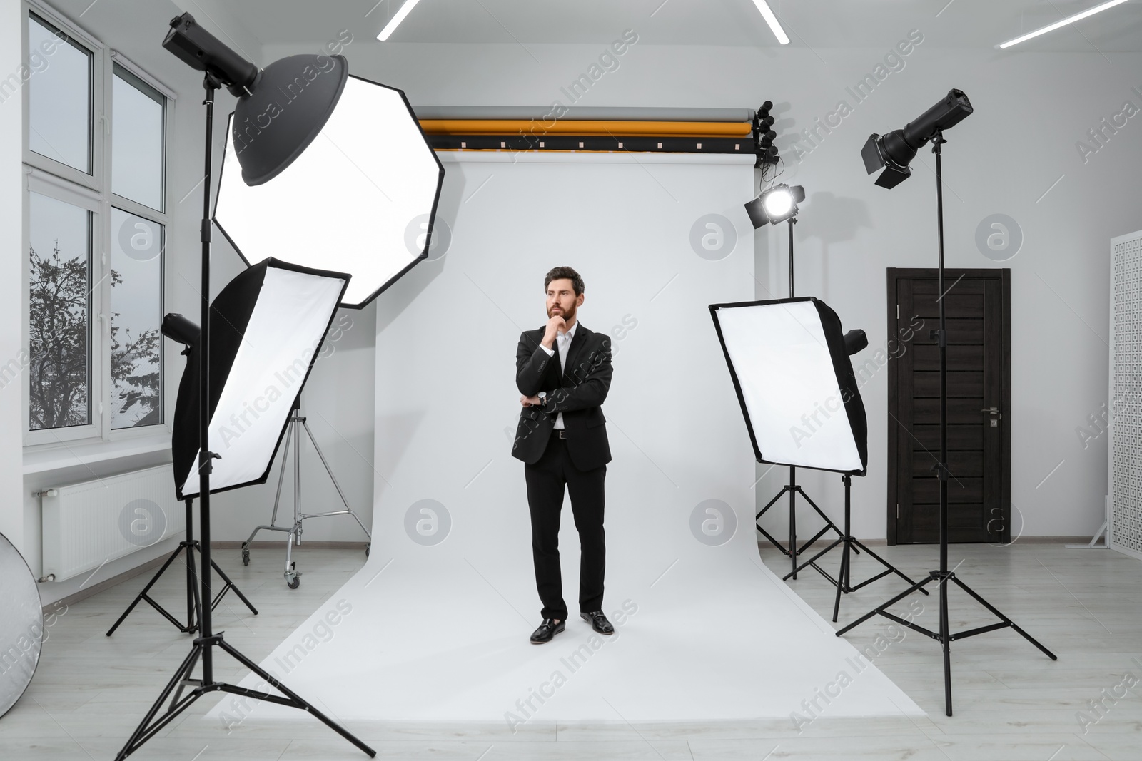 Photo of Handsome model posing in modern studio. Professional photo session