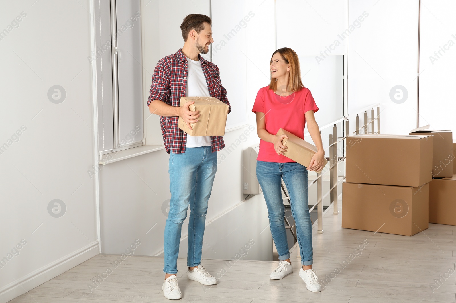 Photo of Couple with moving boxes in their new house