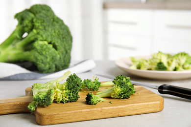 Photo of Raw green broccoli on light grey marble table