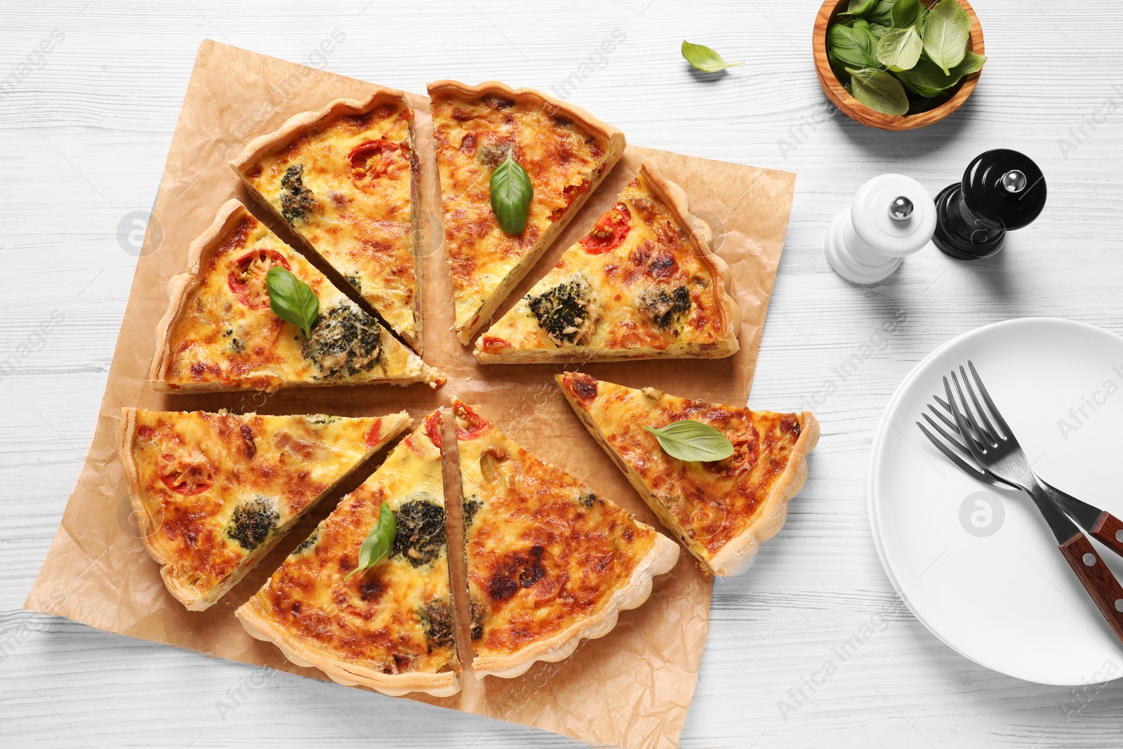 Photo of Delicious homemade vegetable quiche, spices and forks on white wooden table, flat lay