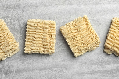 Photo of Flat lay composition with blocks of quick cooking noodles on color background