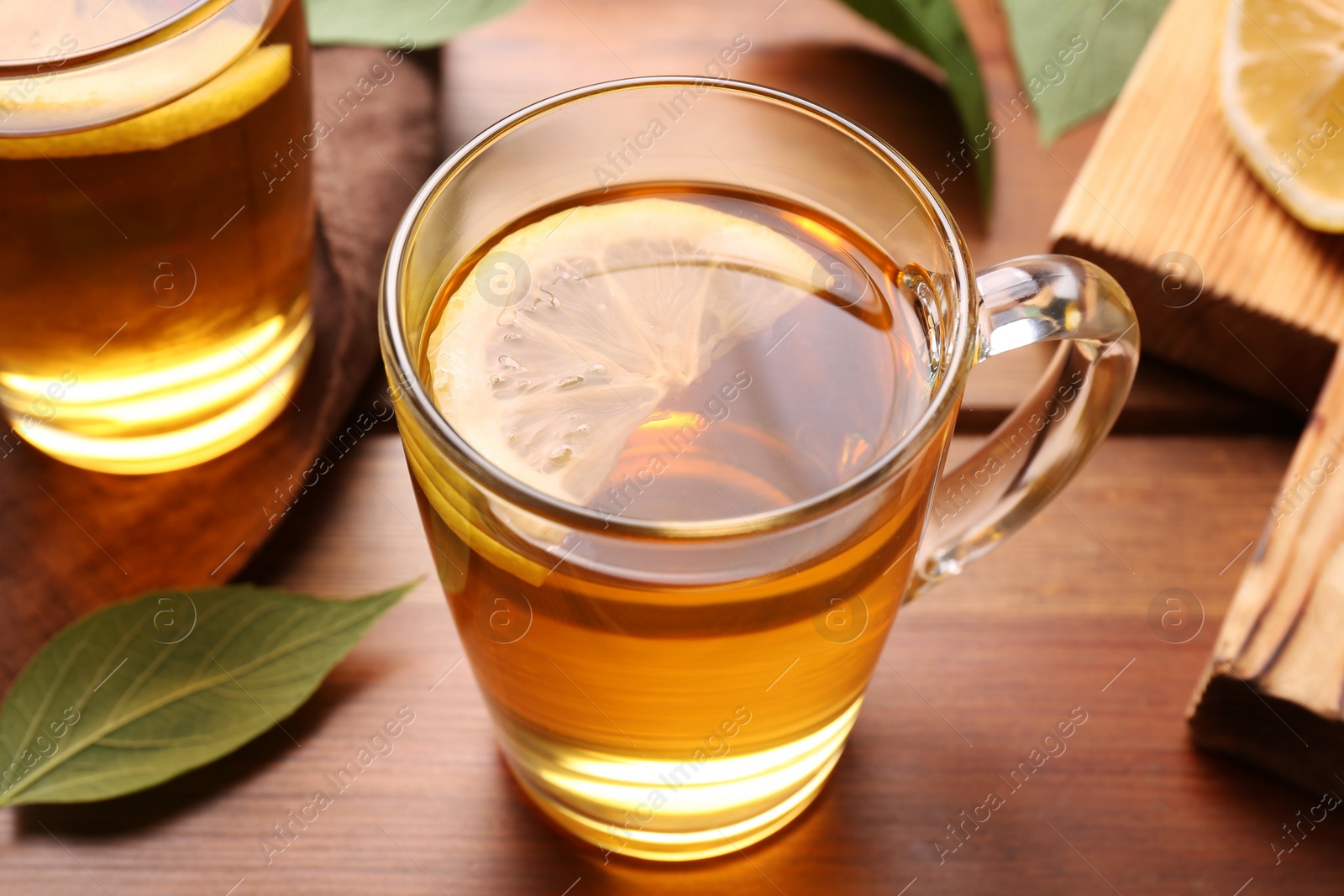 Photo of Cups of tasty iced tea with lemon on wooden table, closeup