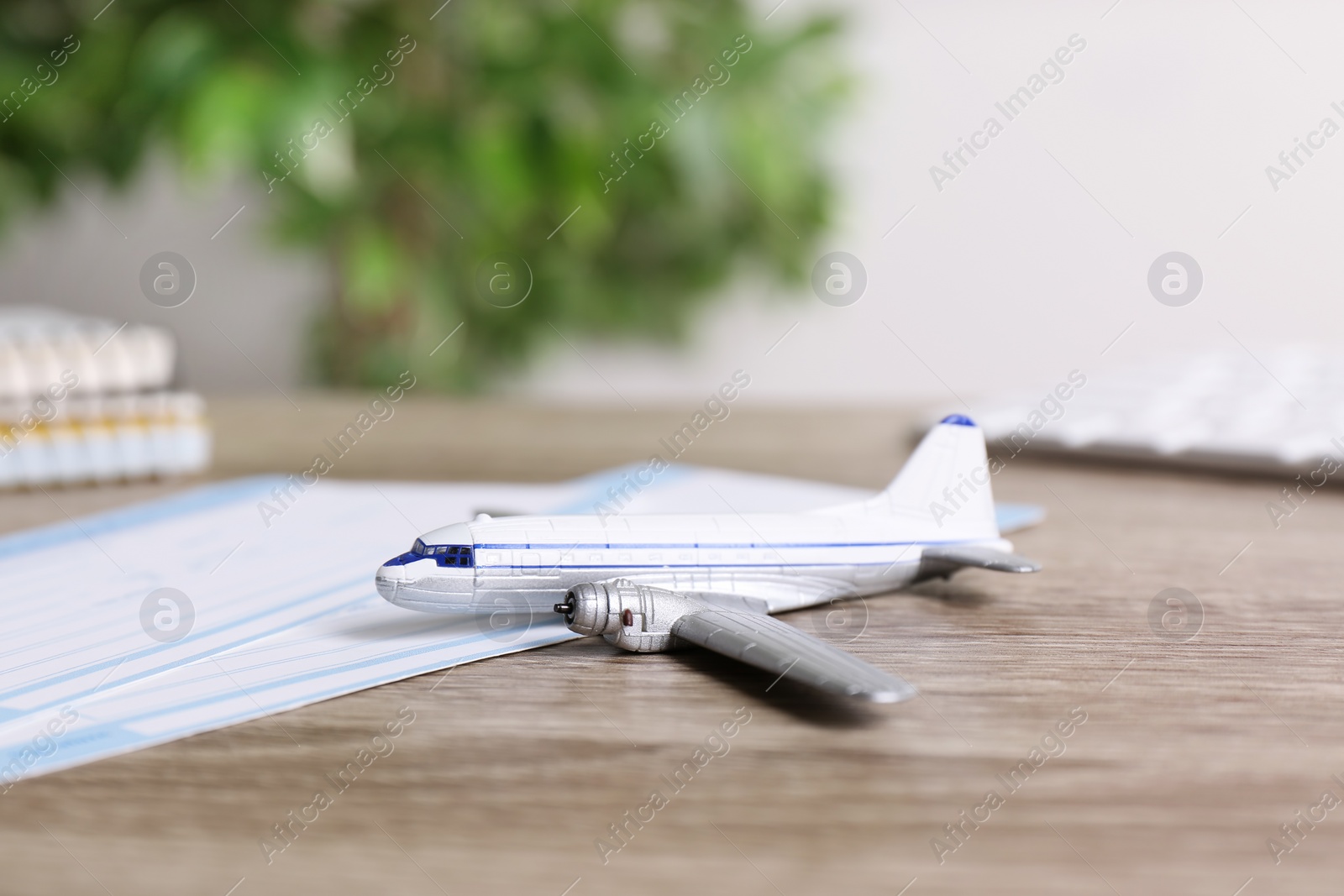 Photo of Plane model on wooden table indoors. Travel agency