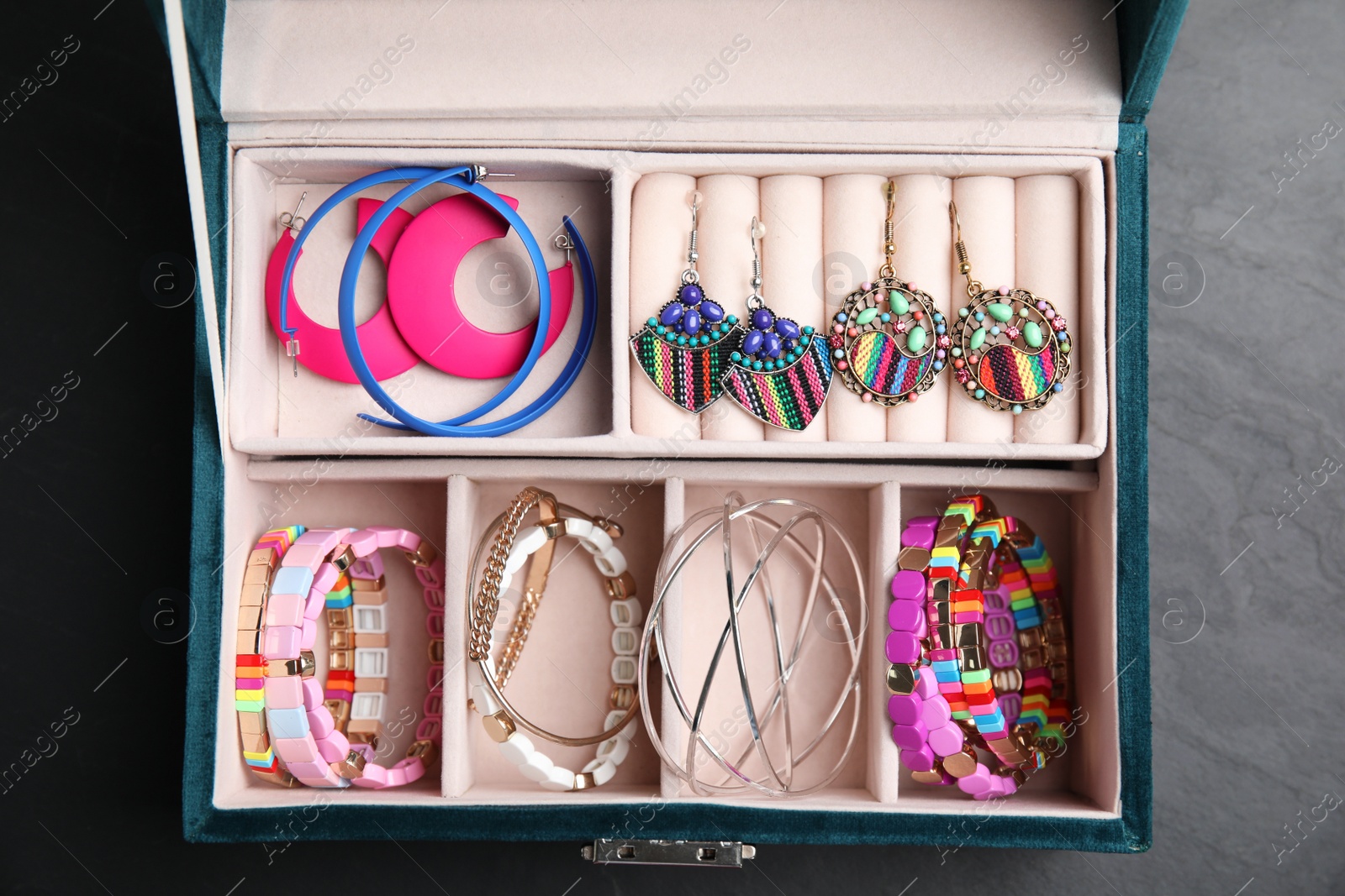 Photo of Elegant jewelry box with beautiful bijouterie on grey table, top view