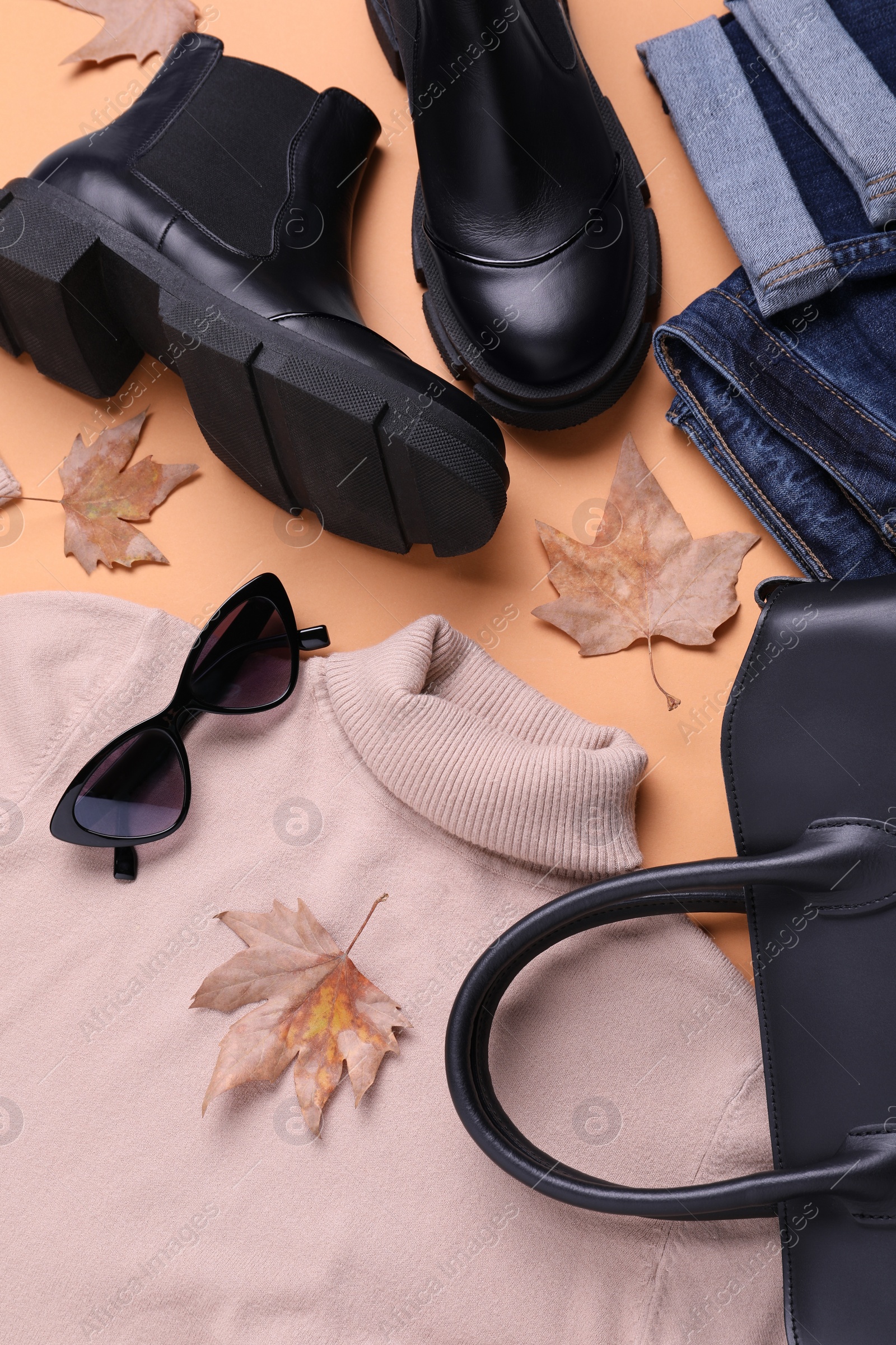 Photo of Fall and winter fashion. Layout with woman's outfit on orange background, top view