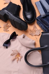 Photo of Fall and winter fashion. Layout with woman's outfit on orange background, top view