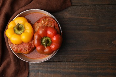 Photo of Delicious stuffed bell peppers on wooden table, top view. Space for text