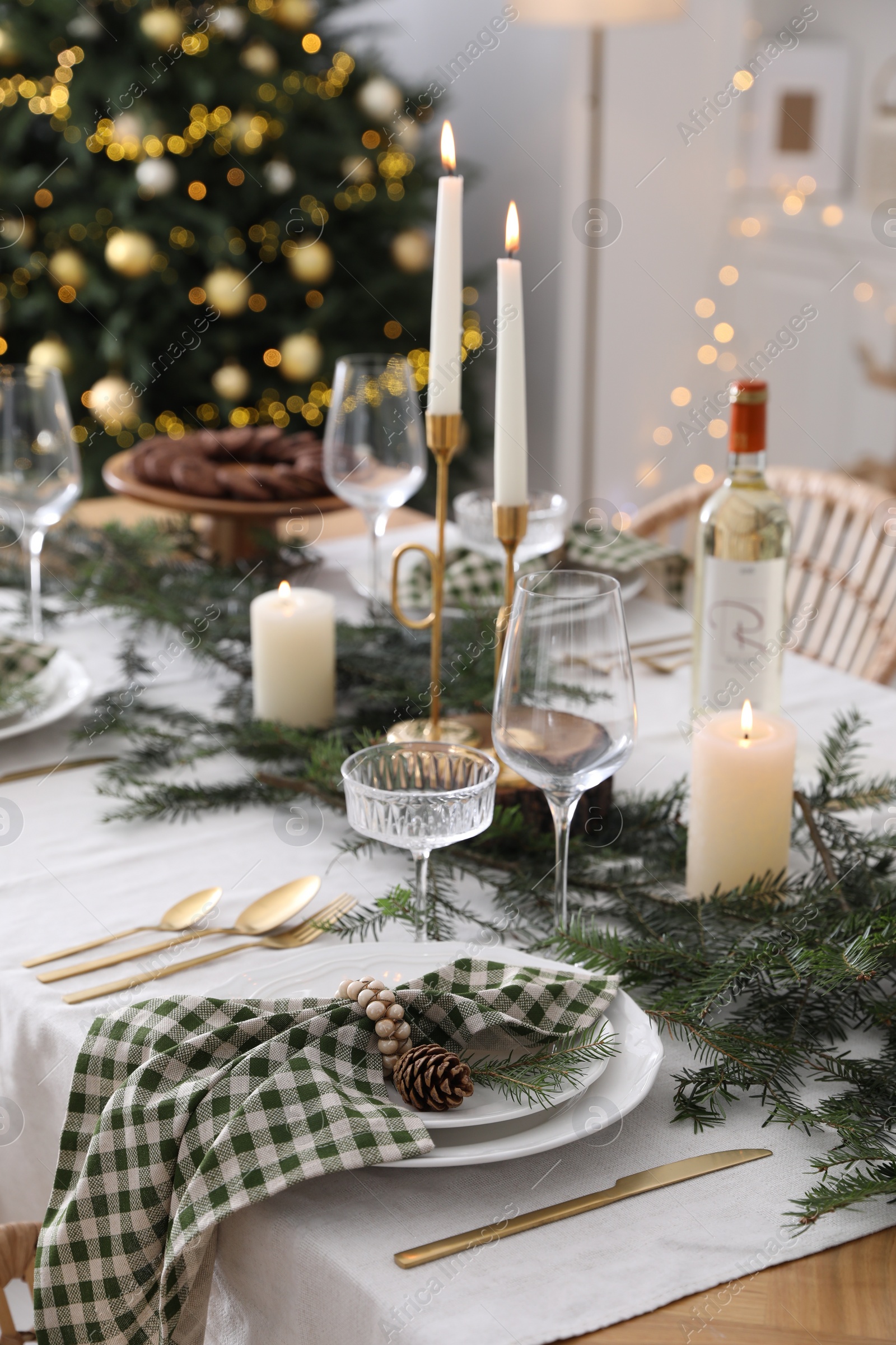 Photo of Christmas table setting with festive decor and dishware in room