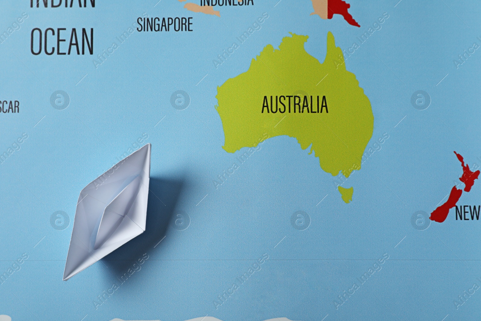 Photo of White paper boat on world map, top view