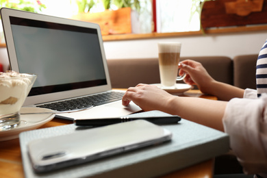 Blogger working with laptop in cafe, closeup