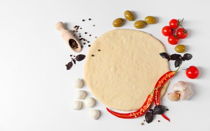 Fresh pizza dough and products on white background, flat lay. Space for text