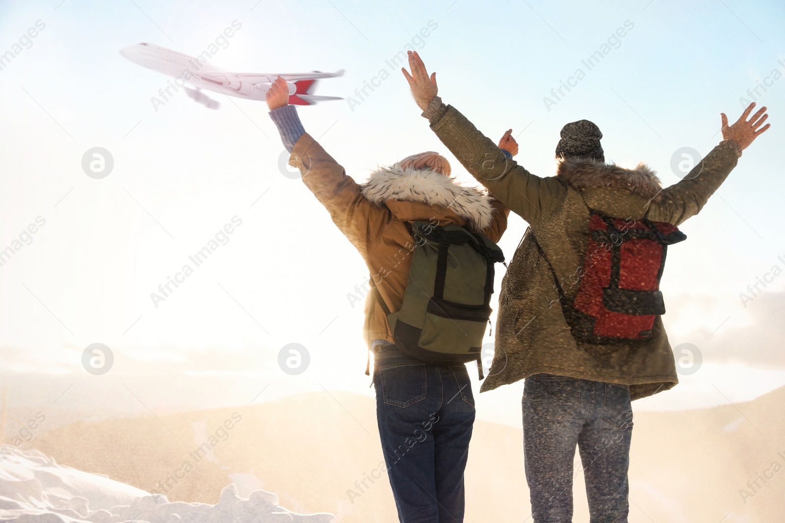 Image of Excited couple in mountains under sky with flying airplane. Winter vacation