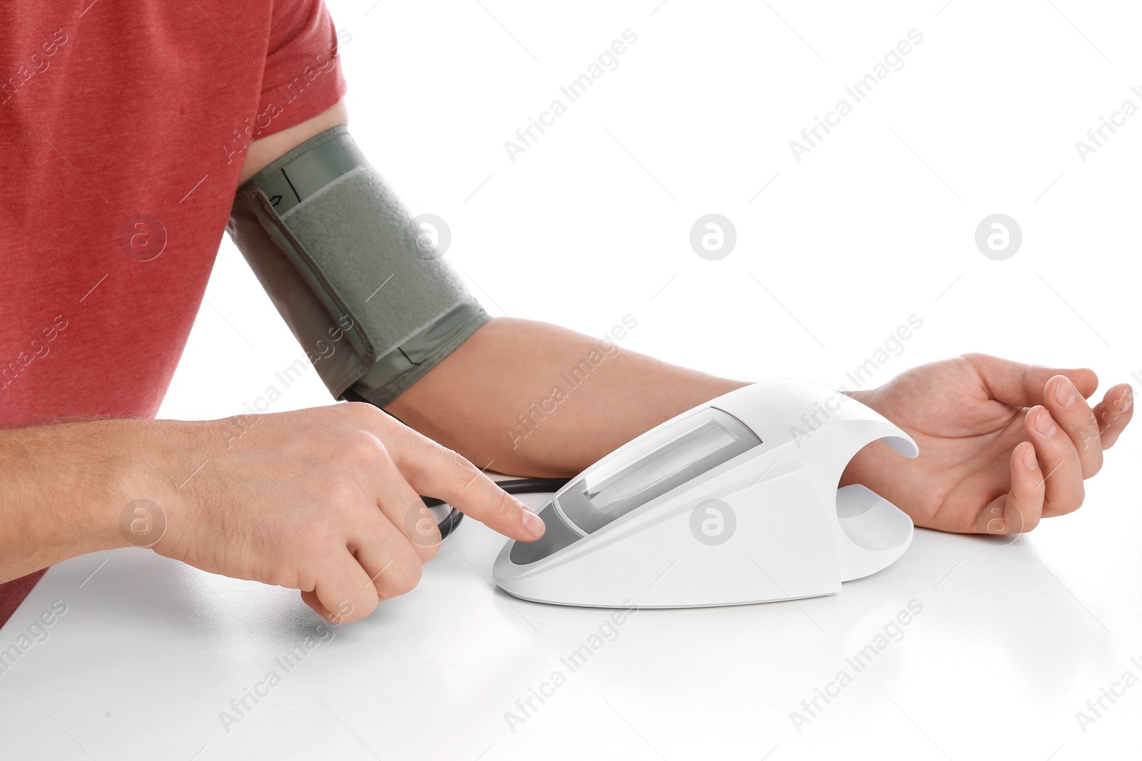 Photo of Man checking blood pressure with sphygmomanometer at table against white background, closeup. Cardiology concept