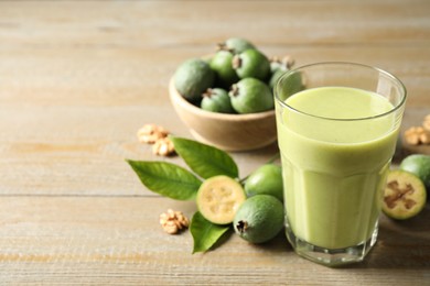 Fresh feijoa smoothie and fresh fruits on wooden table, closeup. Space for text