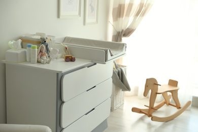 Photo of Modern changing table in baby room interior