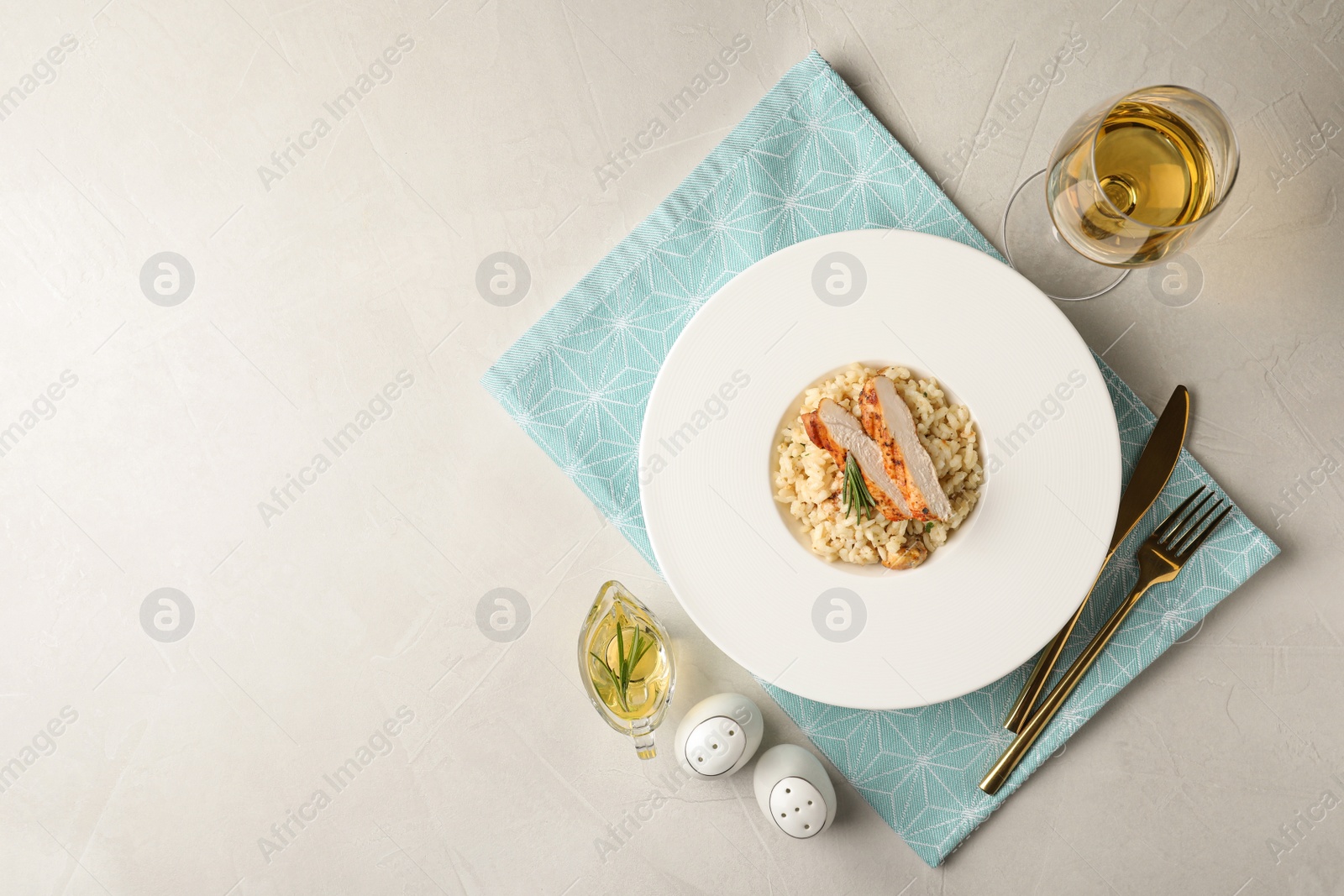 Photo of Delicious chicken risotto served on light grey table, flat lay. Space for text