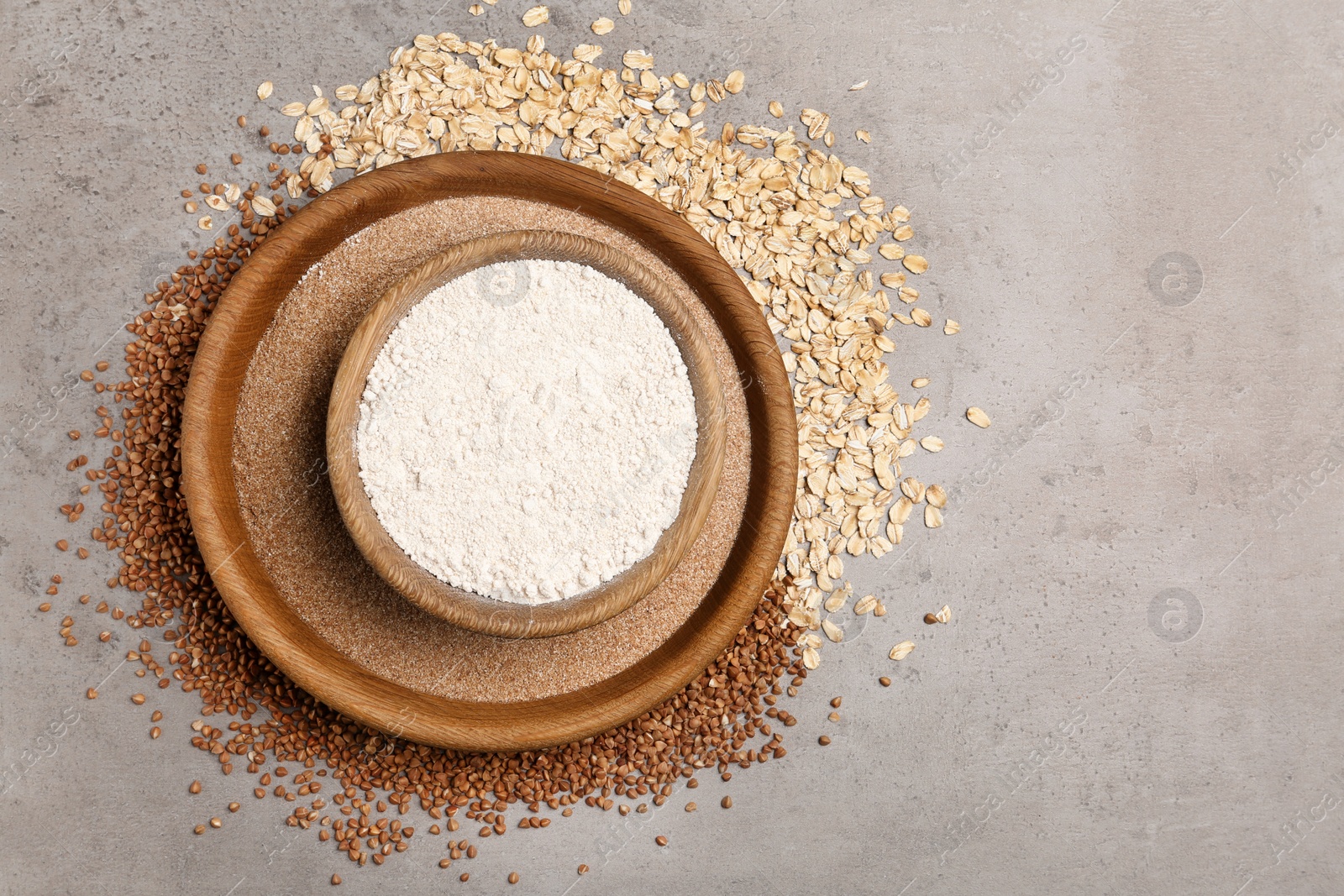 Photo of Composition with oat and buckwheat flour on grey background, top view. Space for text