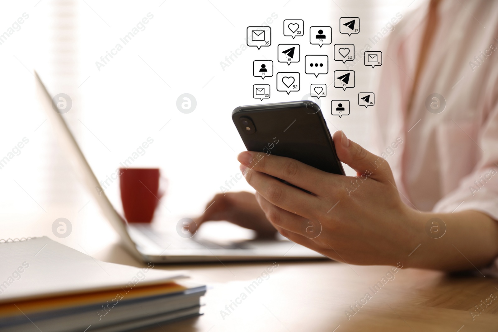 Image of Different virtual icons and young woman using smartphone and laptop at table indoors, closeup. SMM (Social media marketing) concept