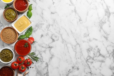 Photo of Flat lay composition with different sauces and space for text on marble background