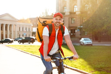 Male courier on bicycle delivering food in city