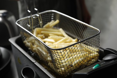 Photo of Cooking delicious french fries in hot oil