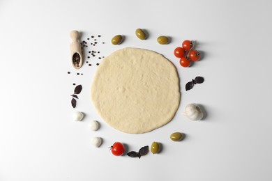 Fresh pizza dough and products on white background, flat lay