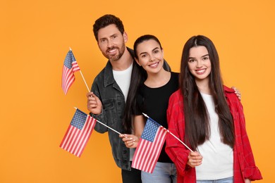 Photo of 4th of July - Independence Day of USA. Happy family with American flags on yellow background