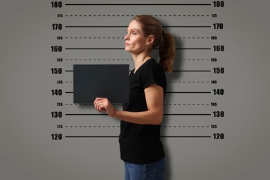 Image of Criminal mugshot. Arrested woman with blank card against height chart