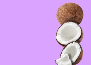 Image of Stack of fresh coconuts on violet background. Space for text