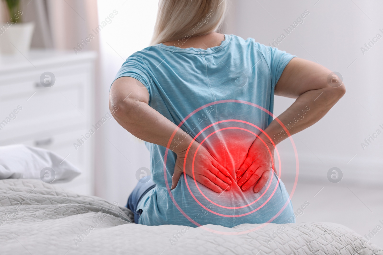 Image of Senior woman suffering from back pain after sleeping on uncomfortable mattress at home, closeup