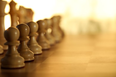 Photo of Wooden chess pieces on checkerboard before game, selective focus. Space for text