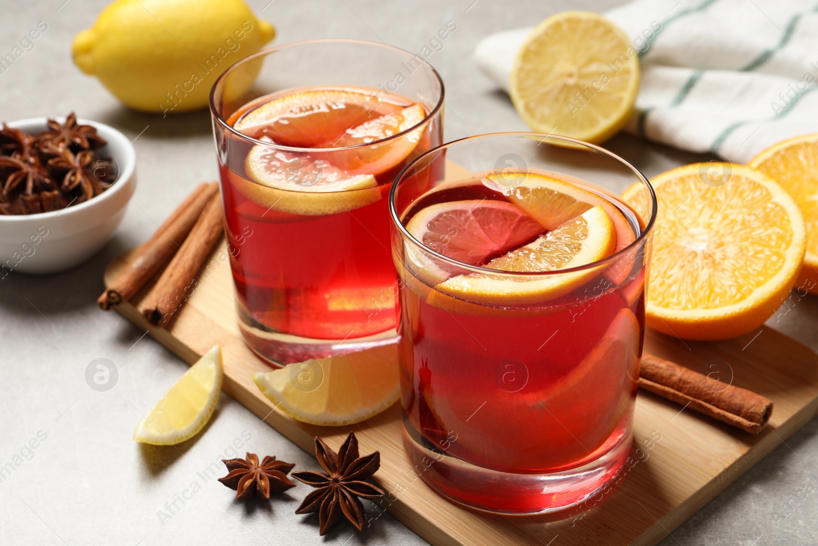 Photo of Aromatic punch drink and ingredients on light grey table