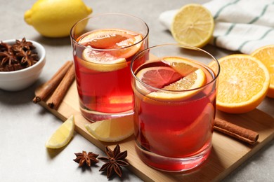 Photo of Aromatic punch drink and ingredients on light grey table