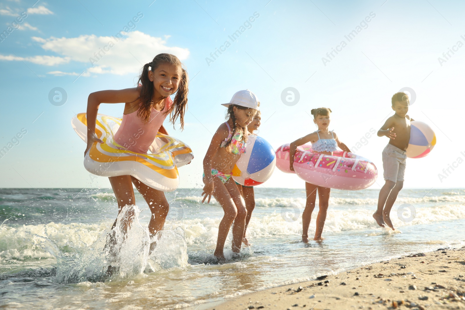 Photo of Cute children enjoying sunny day at beach. Summer camp