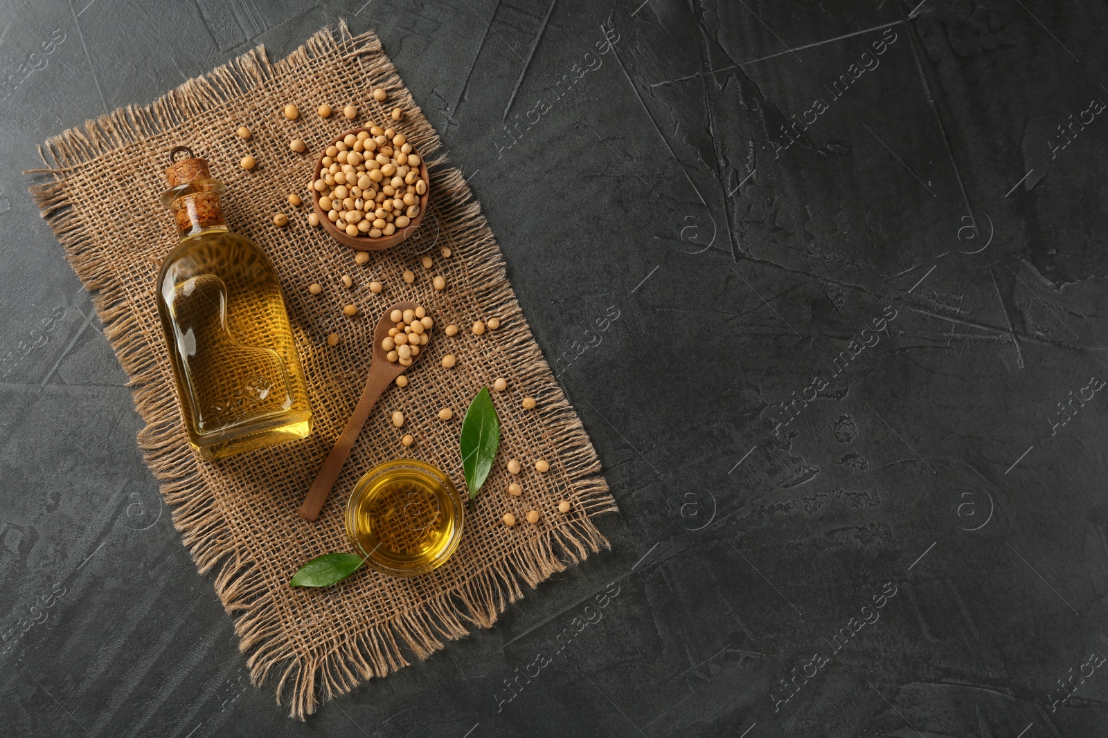 Photo of Flat lay composition with soybean oil on grey table. Space for text