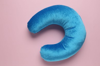 Photo of Light blue travel pillow on pink background, top view