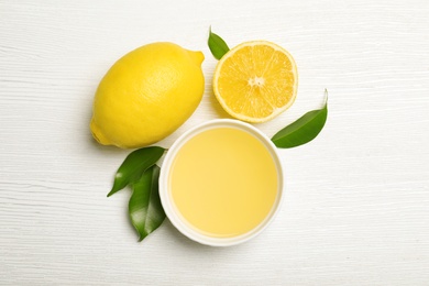 Photo of Composition with freshly squeezed juice and lemons on white wooden background