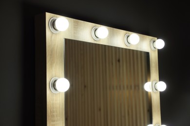 Beautiful mirror with light bulbs in makeup room, closeup