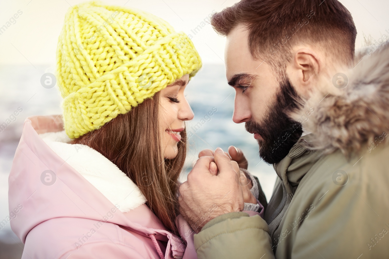 Photo of Lovely young couple holding hands near sea