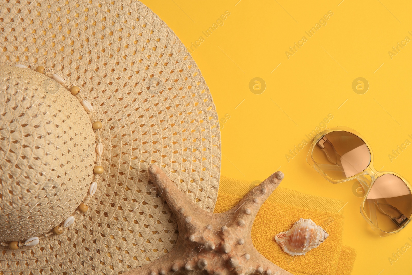 Photo of Beach accessories, shell and starfish on orange background, flat lay