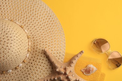 Photo of Beach accessories, shell and starfish on orange background, flat lay