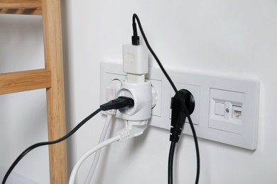 Many different electrical power plugs in sockets indoors