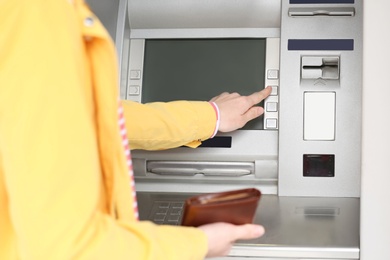 Woman using cash machine for money withdrawal outdoors, closeup