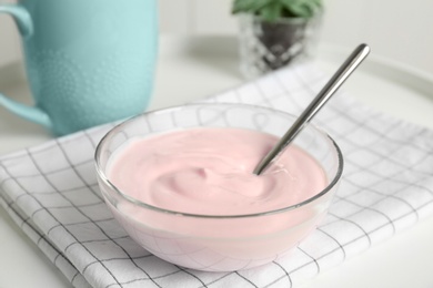 Bowl with yummy yogurt on table