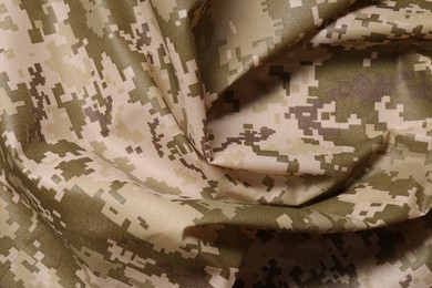 Photo of Texture of crumpled camouflage fabric as background, top view