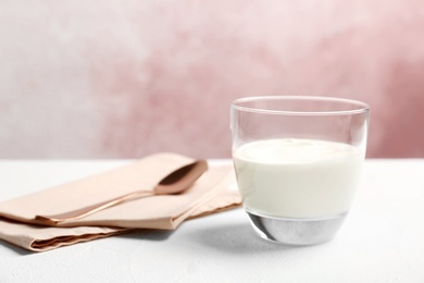 Glass with yummy yogurt on table