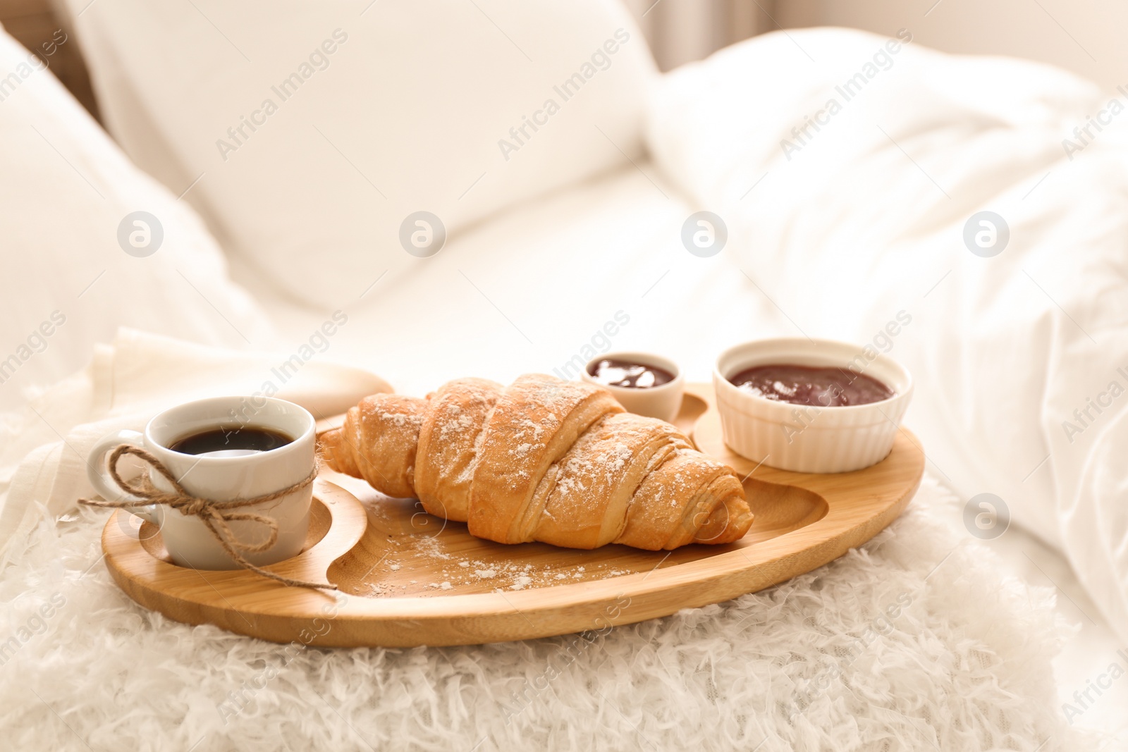 Photo of Delicious morning coffee and croissant on bed