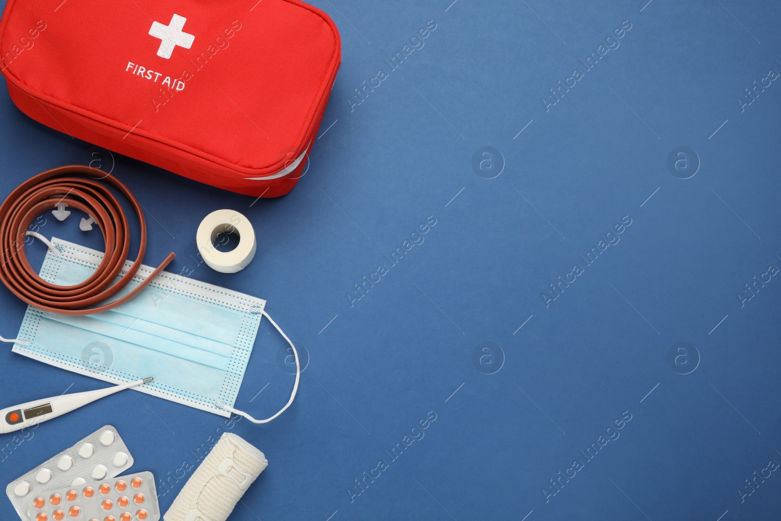 Photo of Flat lay composition with first aid kit on blue background, space for text